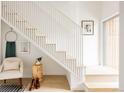Hallway with a staircase featuring light wood steps and white rails, and a sitting chair at 3233 Tejon St # 103, Denver, CO 80211