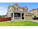 Charming two-story home featuring stone accents, a covered porch, well-kept lawn, and a two car garage at 282 Vialpando St, Brighton, CO 80601