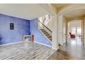 Bright living room boasts hardwood floors, staircase, and a statement wall, creating a modern and inviting space at 282 Vialpando St, Brighton, CO 80601