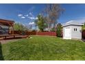 Expansive backyard featuring a lush lawn, wooden deck, and storage shed at 7286 Wolff St, Westminster, CO 80030