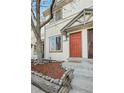 Charming townhouse featuring a vibrant red front door and well-maintained landscaping at 17698 E Loyola Dr # E, Aurora, CO 80013