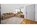Bright living room with neutral walls, plush carpeting, and comfortable sofas with front door at 10530 Mount Columbia Pl, Parker, CO 80138