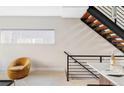 Inviting living space with wooden stairs, a cozy mustard-colored chair, and natural light at 4485 Tennyson St # 5, Denver, CO 80212
