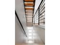 Modern staircase with wooden steps, black metal railings, and a three-panel glass door at the bottom at 4485 Tennyson St # 5, Denver, CO 80212