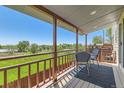 Covered balcony with wood railings and a view of the green fields at 5260 Garrison St # 11, Arvada, CO 80002