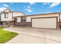 Two-story home featuring a two-car garage and a front patio seating area at 10550 Routt St, Westminster, CO 80021