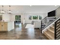Open-concept living room with hardwood flooring, large windows, and modern staircase, perfect for entertaining at 6692 S Robertsdale Way, Aurora, CO 80016