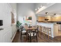 This dining area is adjacent to the kitchen and features a table, six chairs, and modern lighting at 6450 W 44Th Pl # B3, Wheat Ridge, CO 80033