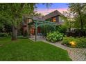Beautiful backyard featuring a stone patio, pergola, manicured lawn, and lush greenery at 1960 Hudson St, Denver, CO 80220