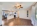 Open-concept living space showcasing hardwood floors, a modern ceiling fan, and seamless transitions to the kitchen at 15756 E Temple Pl, Aurora, CO 80015