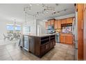 Open kitchen featuring modern track lighting, large island with wine storage, and tile flooring at 13456 Via Varra # 428, Broomfield, CO 80020