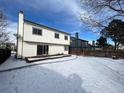 Snowy backyard with deck and partial view of neighboring house at 17984 E Bates Ave, Aurora, CO 80013