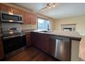 Galley kitchen with stainless steel appliances and wood cabinets at 17984 E Bates Ave, Aurora, CO 80013