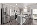 Modern kitchen with stainless steel appliances, gray cabinets, and a quartz countertop island at 515 Bridger Ave, Fort Lupton, CO 80621