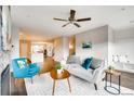 Bright living room with neutral décor, a gray sofa, and an open layout flowing into the kitchen at 2473 S Cherokee St, Denver, CO 80223