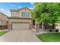 Attractive two-story home featuring a two-car garage and front porch with brick accents at 10197 Quintero St, Commerce City, CO 80022