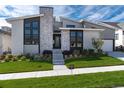 Striking home with a stone facade, modern design, and lush green lawn offers curb appeal at 7125 Skygazer St, Castle Pines, CO 80108