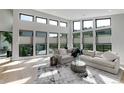 Bright living room boasting large windows, hardwood floors, and stylish modern furnishings at 7125 Skygazer St, Castle Pines, CO 80108