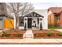Charming home featuring a landscaped front yard, well maintained garden beds, and a welcoming entrance at 1452 S Logan St, Denver, CO 80210