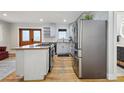 Kitchen with stainless steel refrigerator and range, white cabinets, granite countertops, and hardwood flooring at 31551 Black Widow Dr, Conifer, CO 80433