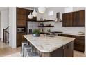 Stylish kitchen featuring a large island with granite countertops, stainless steel appliances, and dark wood cabinets at 6631 Alan Dr, Denver, CO 80221