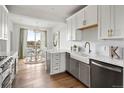 Modern kitchen with stainless steel appliances, island, and adjacent dining area with ample natural light at 888 S Valentia St # 102, Denver, CO 80247