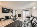 Living room features L-shaped sectional sofa, stone fireplace, and a large TV at 1475 S Quebec Way # H38, Denver, CO 80231