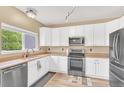 Well-equipped kitchen with white cabinets, stainless steel appliances, and a functional layout at 19463 E Hollow Creek Dr, Parker, CO 80134
