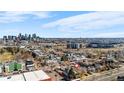 Aerial view of neighborhood homes with the city skyline in the background on a clear day at 2146 Federal Blvd, Denver, CO 80211