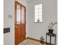 Classic entryway with a beautiful wood door, decorative glass, and stylish tile flooring at 1600 Olive St, Denver, CO 80220