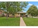 Quaint single-story home with a welcoming front porch and lush green lawn leading to the entrance at 1600 Olive St, Denver, CO 80220