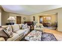 Spacious living room with hardwood floors, neutral decor, and access to the dining area at 1600 Olive St, Denver, CO 80220