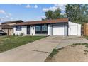 Exterior view of single-story home featuring a well-manicured lawn and long driveway at 8641 Lowell Blvd, Westminster, CO 80031