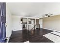 View of the open-concept living room with dark hardwood floors and access to the kitchen at 8641 Lowell Blvd, Westminster, CO 80031