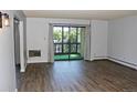 Bright living room features wood-look floors and balcony with sliding glass doors at 14152 E Linvale Pl # 311, Aurora, CO 80014