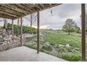 Covered outdoor space with concrete flooring offering views of the sprawling grassy landscape at 1062 Pinon Ln, Elizabeth, CO 80107
