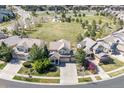 Aerial view of suburban home with landscaping, a three-car garage, and a community park nearby at 23580 E Portland Way, Aurora, CO 80016