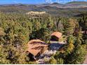 Breathtaking aerial view of a mountain home nestled amongst a dense forest with scenic views at 31084 Kings Valley Dr, Conifer, CO 80433