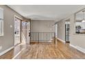 Inviting entryway boasting gleaming hardwood floors, a decorative railing, and an open doorway to the kitchen, offering a warm welcome at 436 Pluto Ct, Lone Tree, CO 80124