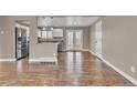 Spacious living area featuring hardwood floors, neutral paint colors, and abundant natural light, with seamless transition to the kitchen at 436 Pluto Ct, Lone Tree, CO 80124