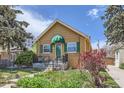 Delightful home exterior highlighting garden, fresh green lawn, and a covered front porch, blending comfort with curb appeal at 1559 Elm St, Denver, CO 80220