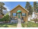 Charming single-story home featuring a quaint front porch, green shutters, and landscaped garden at 1559 Elm St, Denver, CO 80220