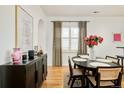 Dining room with dark wood accents, hardwood floors, and designer curtains at 150 S Harrison St # 106, Denver, CO 80209