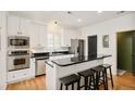Modern kitchen with stainless steel appliances, black countertops, and breakfast bar at 150 S Harrison St # 106, Denver, CO 80209