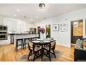 Well-lit kitchen and dining area with a black table and island seating at 150 S Harrison St # 106, Denver, CO 80209