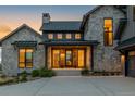 Inviting stone home with a covered front entrance and manicured landscaping at 2442 Fox View Trl, Franktown, CO 80116