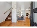 Inviting entryway with hardwood floors and an open floor plan leading to the dining area and kitchen at 10165 E 59Th Ave, Denver, CO 80238