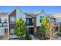 Attractive townhouse featuring a modern design, balcony, and manicured front yard at 10165 E 59Th Ave, Denver, CO 80238