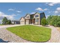 Expansive front yard with a well-maintained lawn and decorative rock landscaping surrounding a beautiful two story home at 42311 Forest Oaks Dr, Elizabeth, CO 80107