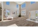 Bright living room with soaring ceilings, large windows, and a cozy chaise lounge for ultimate relaxation at 42311 Forest Oaks Dr, Elizabeth, CO 80107